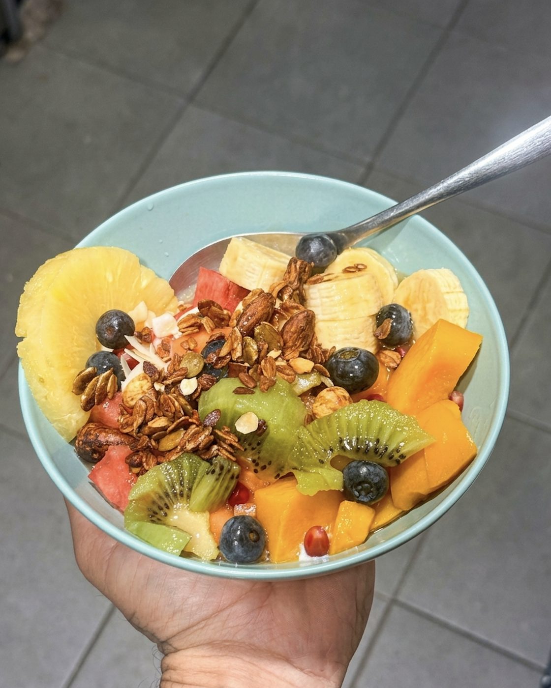 Bol de frutas con granola, kiwi, papaya, plátano y arándanos